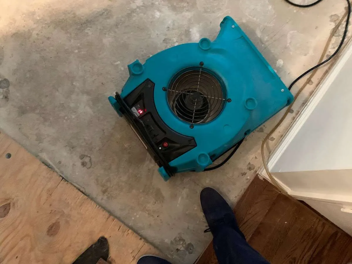 Air mover drying subfloor during Leak Detection & Repair in Bondurant